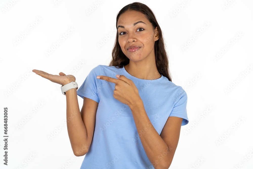 Beautiful girl wearing blue T-shirt pointing and holding hand showing adverts Beautiful girl wearing blue T-shirt pointing and holding hand showing adverts