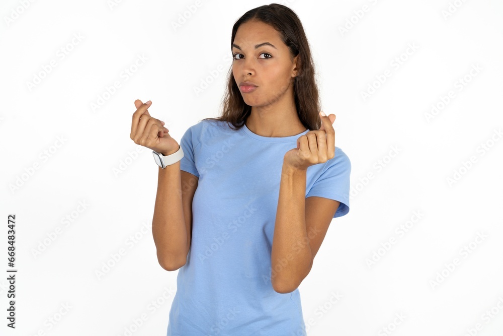 Beautiful girl wearing blue T-shirt doing money gesture with hands, asking for salary payment, millionaire business Beautiful girl wearing blue T-shirt doing money gesture with hands, asking for salary payment, millionaire business