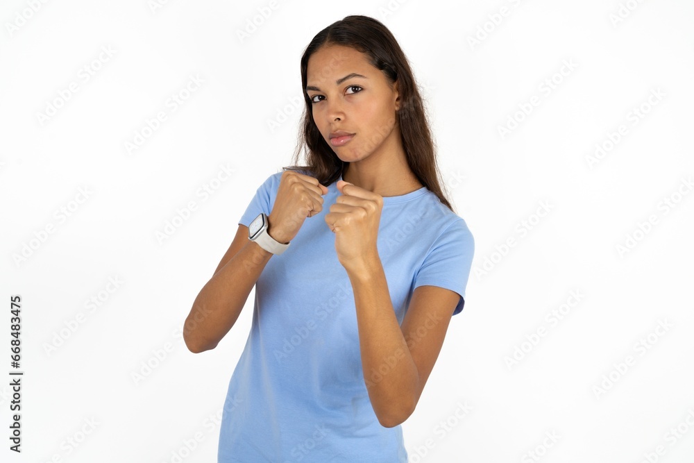 Beautiful girl wearing blue T-shirt Ready to fight with fist defense gesture, angry and upset face, afraid of problem. Beautiful girl wearing blue T-shirt Ready to fight with fist defense gesture, angry and upset face, afraid of problem.