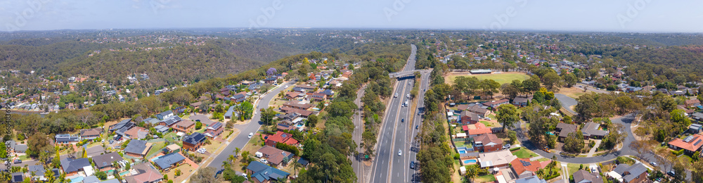 Panoramic aerial drone view of homes and streets above Bangor in the Sutherland Shire, south Sydney, NSW Australia showing Bangor Bypass in the background 