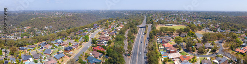 Panoramic aerial drone view of homes and streets above Bangor in the Sutherland Shire, south Sydney, NSW Australia showing Bangor Bypass in the background 