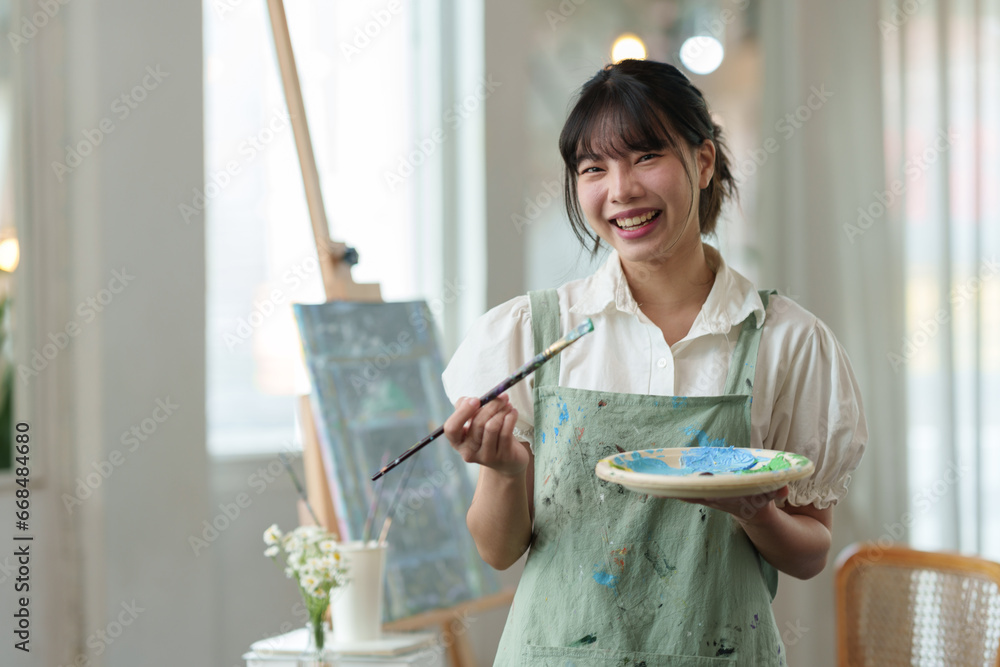 Young female student studying in the art studio Learn how to draw landscapes Mixing watercolors to create art on cardboard design on canvas Develop your art drawing skills with hobby studio activities Young female student studying in the art studio Learn how to draw landscapes Mixing watercolors to create art on cardboard design on canvas Develop your art drawing skills with hobby studio activities