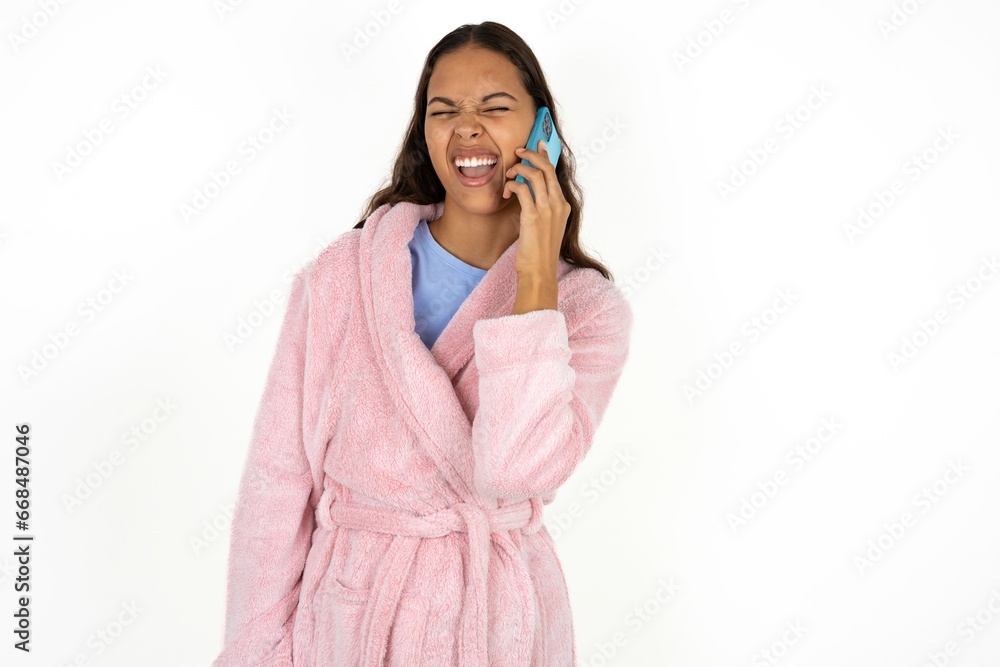 Overemotive happy Young woman laughs out positively hears funny story from friend during telephone conversation Overemotive happy Young woman laughs out positively hears funny story from friend during telephone conversation