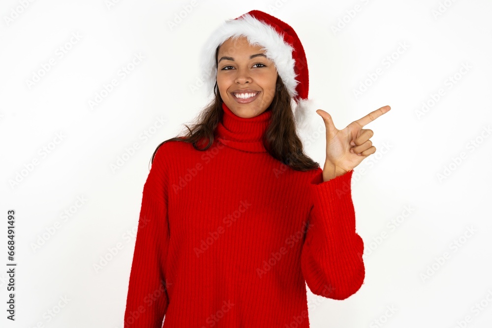Beautiful woman wearing christmas hat pointing up with fingers number eight in Chinese sign language BÄ. Beautiful woman wearing christmas hat pointing up with fingers number eight in Chinese sign language BÄ.