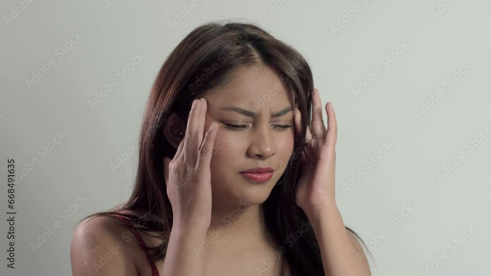 Girl suffering from migraine, massaging temples with fingers, seeking relief and calmness for the headache pain Girl suffering from migraine, massaging temples with fingers, seeking relief and calmness for the headache pain