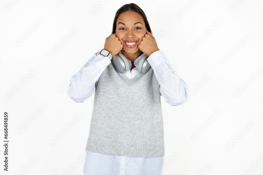 Happy Young beautiful woman keeps fists on cheeks smiles broadly and has positive expression being in good mood Happy Young beautiful woman keeps fists on cheeks smiles broadly and has positive expression being in good mood