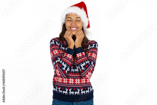 Beautiful woman wearing christmas sweater grins joyfully  imagines something pleasant  copy space. Pleasant emotions concept.