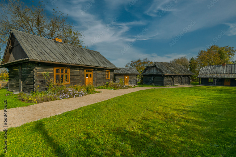 Obraz premium Three wooden country cottages in the town of Niepolomice, Poland.