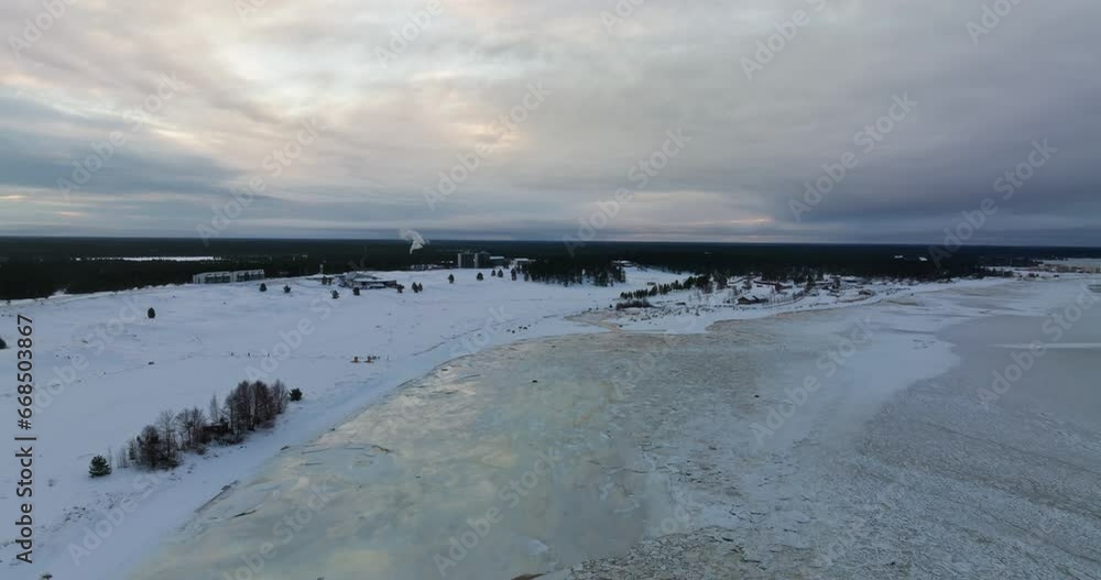 Aerial view rising over weak ice, toward the Kalajoen hiekkasarkat resort, winter evening in Finland Aerial view rising over weak ice, toward the Kalajoen hiekkasarkat resort, winter evening in Finland