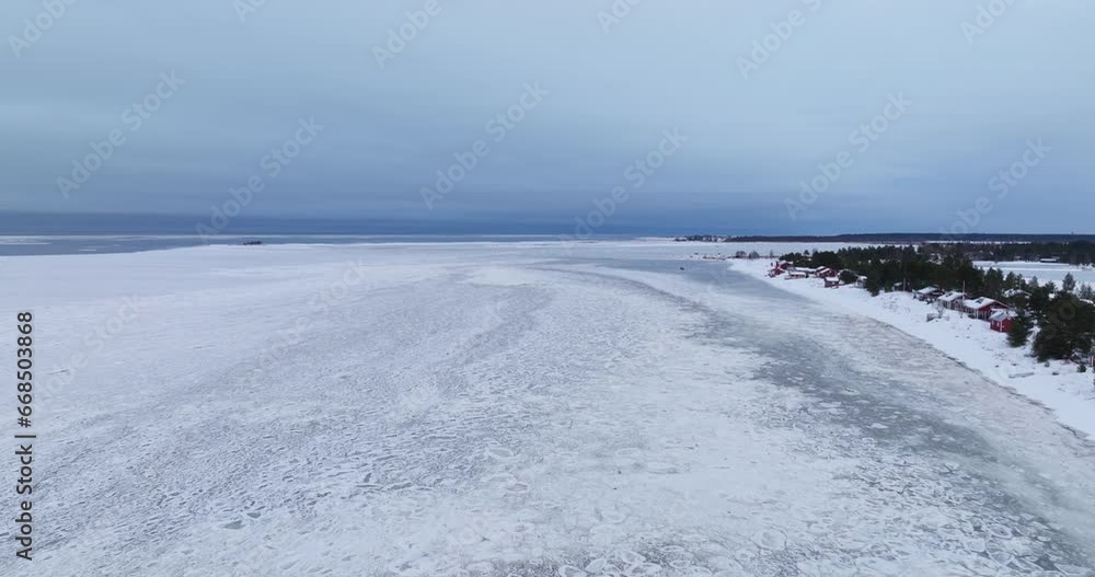 Aerial view over weak ice, dark, winter evening on the coastline of Finland Aerial view over weak ice, dark, winter evening on the coastline of Finland