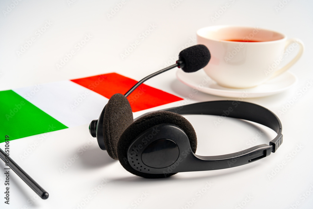 Flag of Italy, cup of tea and headphones on white background Flag of Italy, cup of tea and headphones on white background