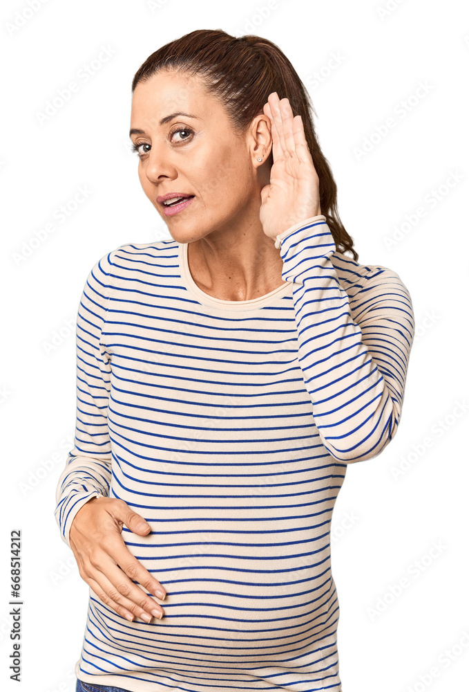 Pregnant middle-aged woman in studio setting trying to listening a gossip. Pregnant middle-aged woman in studio setting trying to listening a gossip.