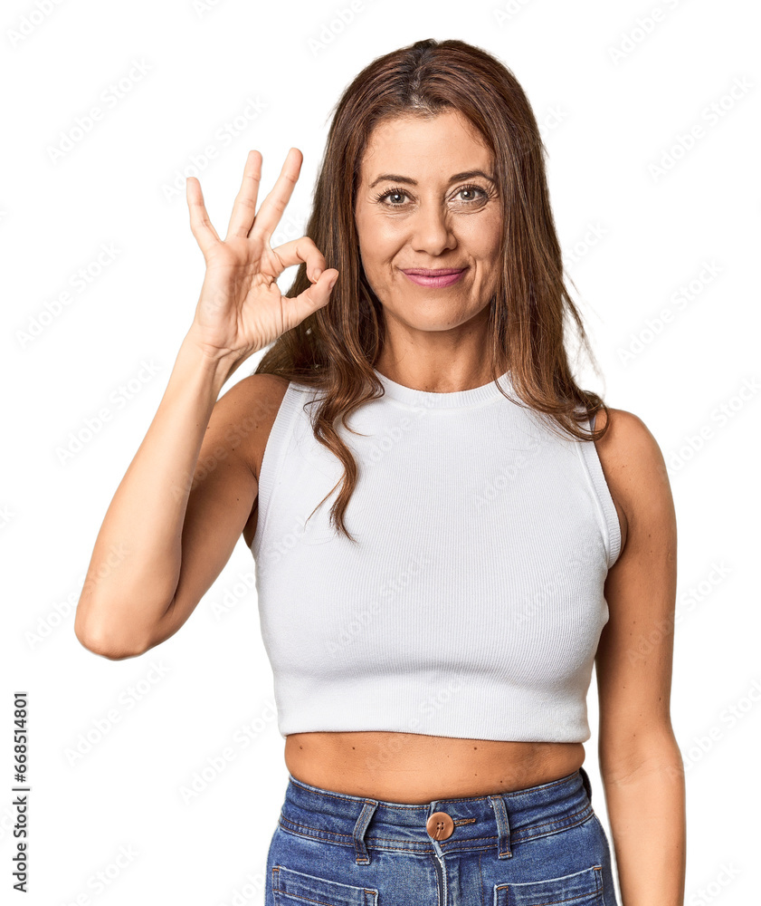 Middle-aged woman portrait in studio setting cheerful and confident showing ok gesture. Middle-aged woman portrait in studio setting cheerful and confident showing ok gesture.
