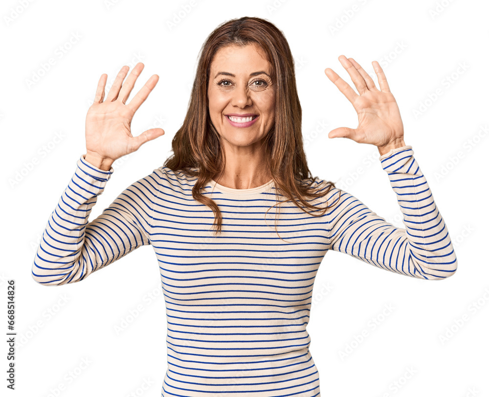 Middle-aged woman portrait in studio setting showing number ten with hands. Middle-aged woman portrait in studio setting showing number ten with hands.