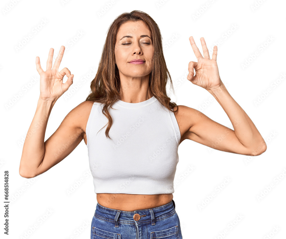 Middle-aged woman portrait in studio setting relaxes after hard working day, she is performing yoga. Middle-aged woman portrait in studio setting relaxes after hard working day, she is performing yoga.