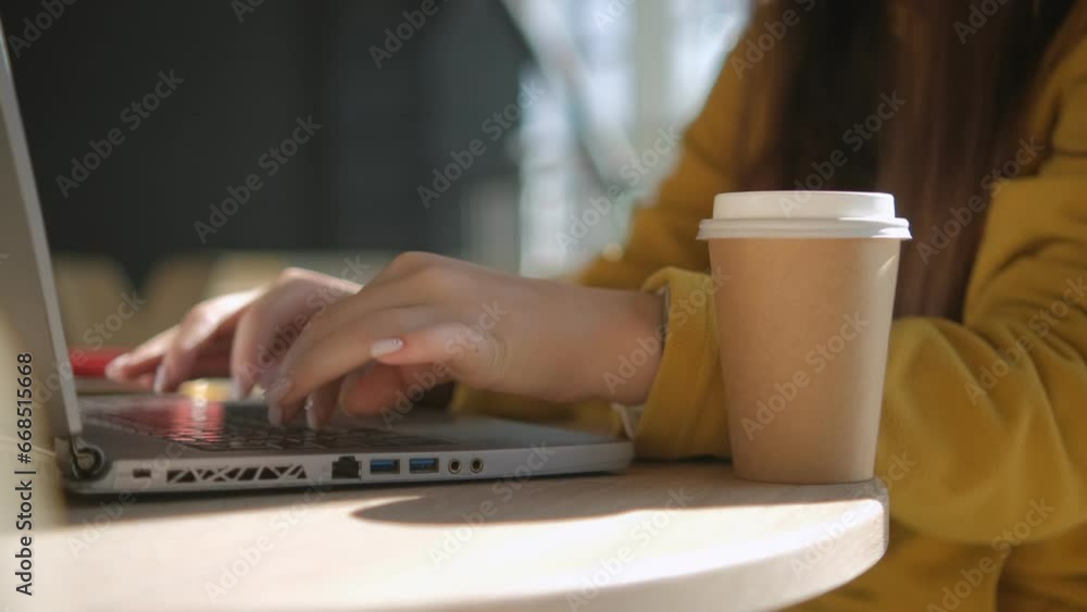 Side view. Hand of girl using texting mobile phone or chat in cafe morning and sunlight. Close up of young woman hand Side view. Hand of girl using texting mobile phone or chat in cafe morning and sunlight. Close up of young woman hand