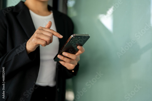Cropped image of a businesswoman typing on her smartphone. chatting, messaging, texting