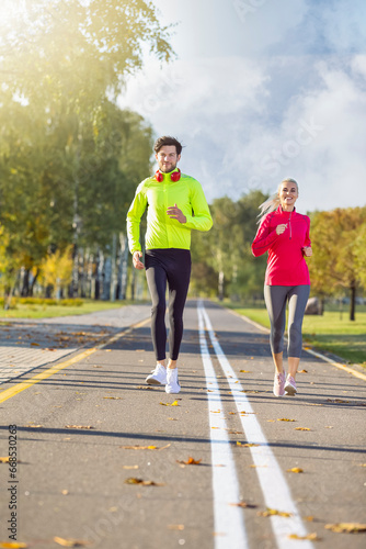 Sport Concepts. Positive Running Couple During Happily Jogging Outside as Runners Training Outdoors Working Out in City