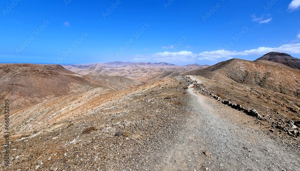 Hiking on gravel roads through the desert mountains on the Spanish island of Fuerteventura