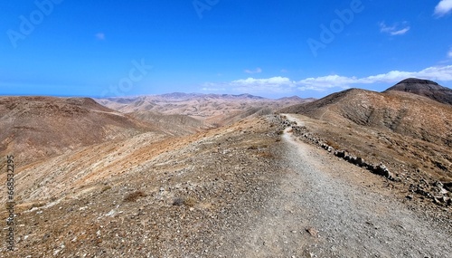 Hiking on gravel roads through the desert mountains on the Spanish island of Fuerteventura