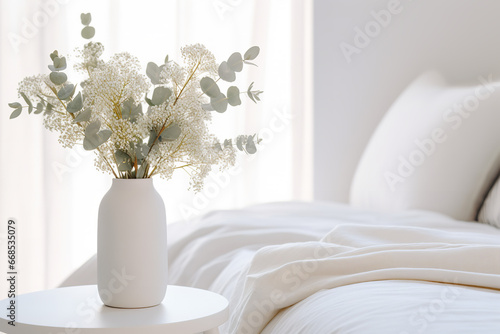 Vase with eucalyptus and gypsophila in a white bedroom