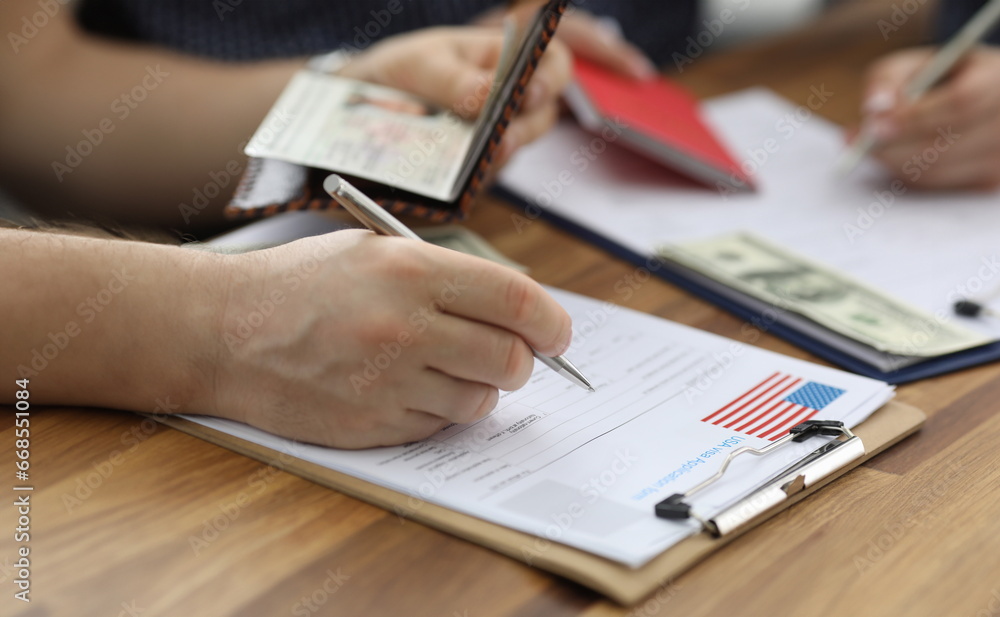 Close-up of person carry information from passport to usa visa application form. Man planning to move abroad. International and legal immigration concept Close-up of person carry information from passport to usa visa application form. Man planning to move abroad. International and legal immigration concept