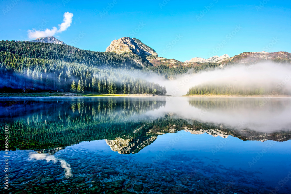 Morning on a mountain lake. View at Black Lake on Durmitor Mountain in Montenegro. HDR Image (High Dynamic Range). Morning on a mountain lake. View at Black Lake on Durmitor Mountain in Montenegro. HDR Image (High Dynamic Range).