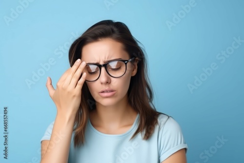 Young woman vision problem wearing glasses on blue background. Person massage her head. Generate Ai