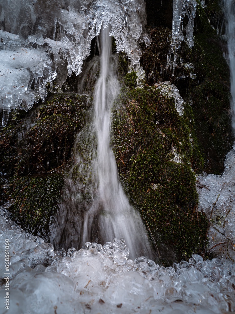Icy frozen winter waterfall in a mossy forest Icy frozen winter waterfall in a mossy forest