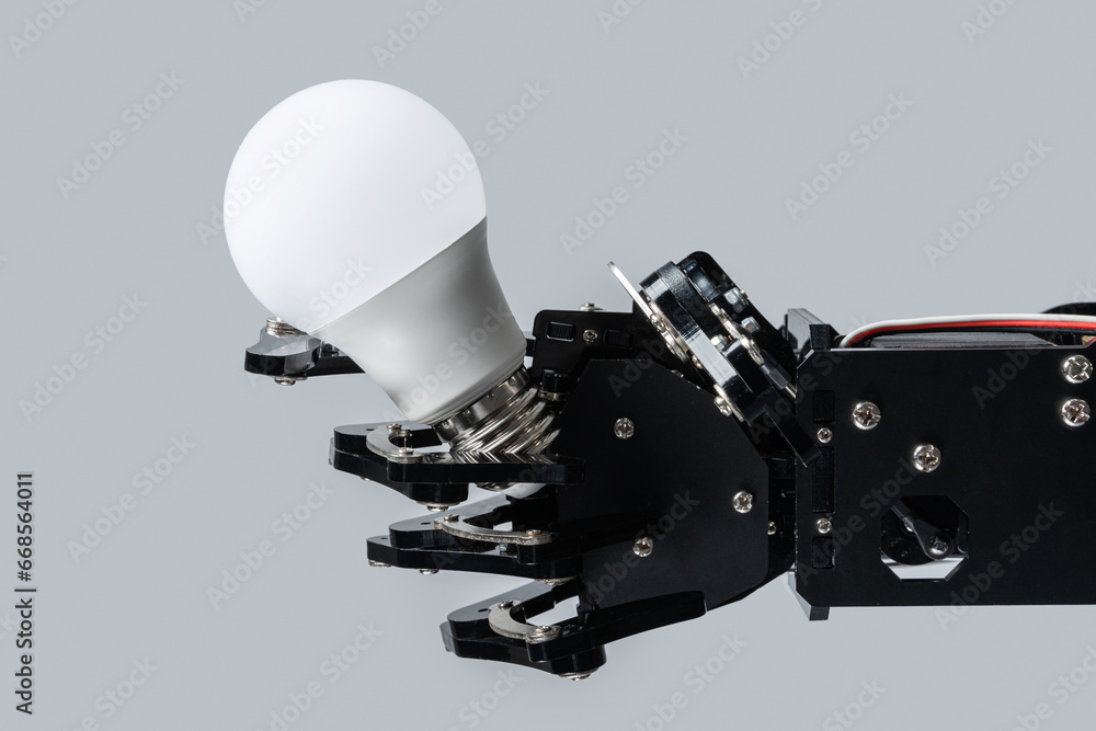 Real robot's hand holding lightbulb. Concepts of artificial intelligence development and machine learning.