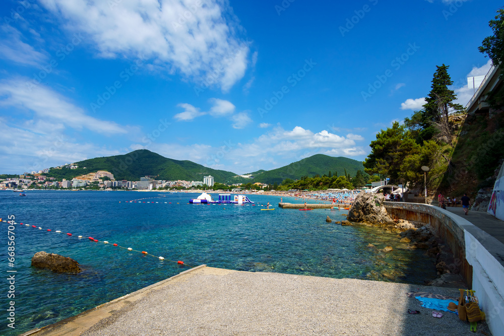 summer vacation seascape, beautiful seaside resort, beach, city in the distance and hotels on the mountainside, adriatic sea