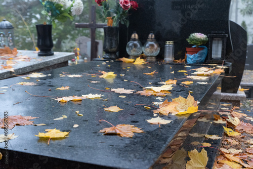 Warsaw, Poland - October 24, 2023: Graves in the cemetery on a cloudy, foggy day. Weather for All Saints' Day. Candles and flowers on graves.