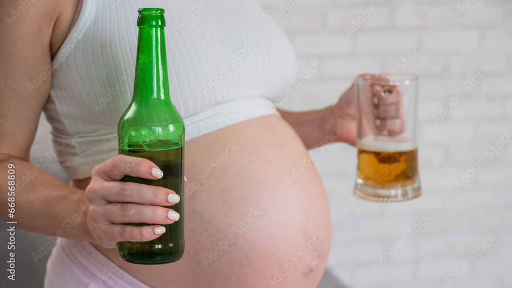 Pregnant woman holding glass and bottle of beer. Pregnant woman holding glass and bottle of beer.