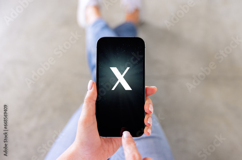 Mobile phone with a letter X on the screen. Custom made font, not a trademark.