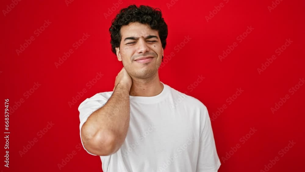 Young latin man suffering for cervical pain standing over isolated red background Young latin man suffering for cervical pain standing over isolated red background