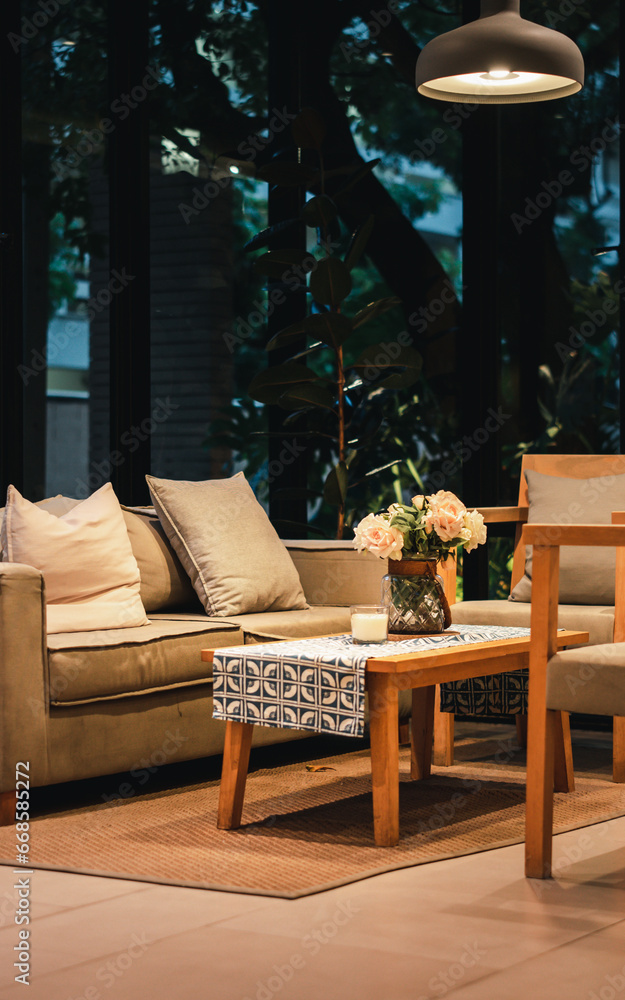 Fototapeta premium Interior design of cozy living room with stylish sofa, coffee table, dired flowers in vase, mock up poster, carpet, decoration, pillows, plaid and personal accessories in modern home decor. Template. 