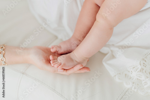 A small child's foot in his mother's hand. Concept of mom's love and care.