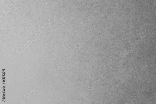 Light gray tone color paint on environmental friendly cardboard box blank kraft recycled paper texture background minimal industry style with space
