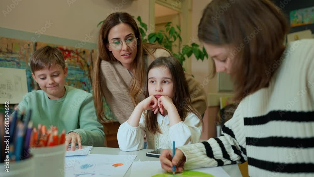 Positive teacher speaking to the children in art class Positive teacher speaking to the children in art class