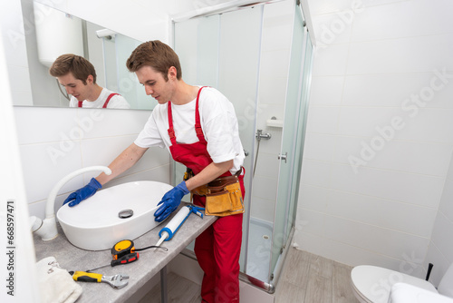 plumber service. Plumber portrait near wash basin siphon installation.