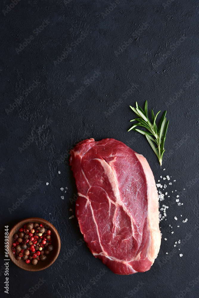 Raw organic marbled beef steak with spices. Top view with copy space.