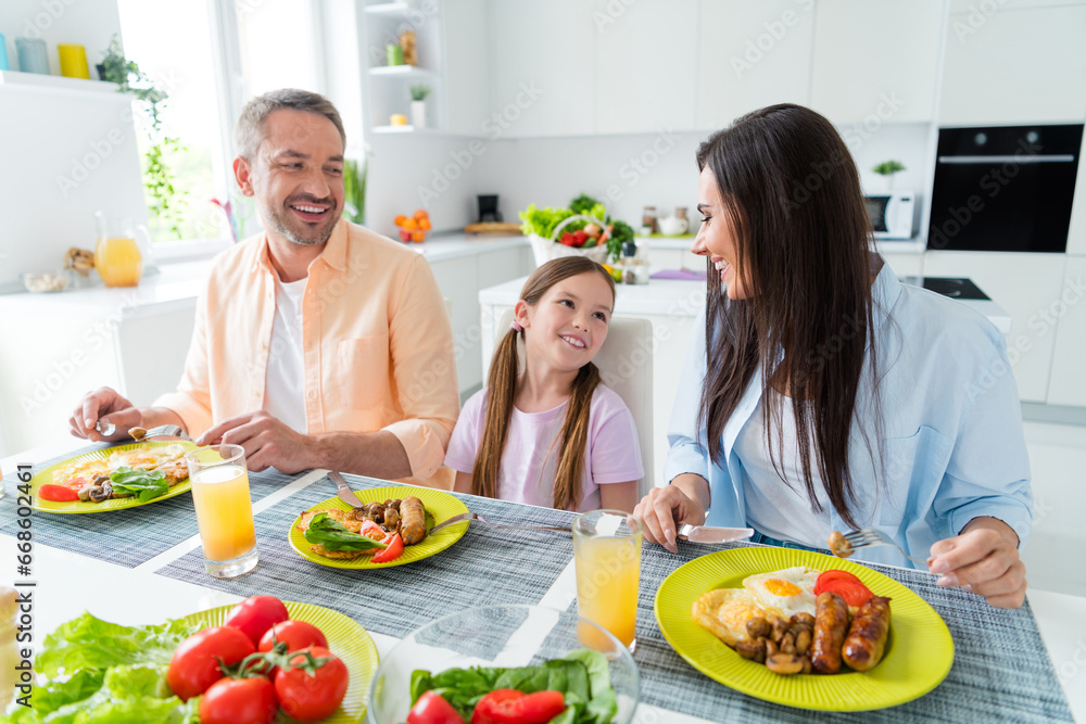 Photo of pretty cheerful wife husband little girl communicating enjoying tasty breakfast indoors apartment kitchen Photo of pretty cheerful wife husband little girl communicating enjoying tasty breakfast indoors apartment kitchen