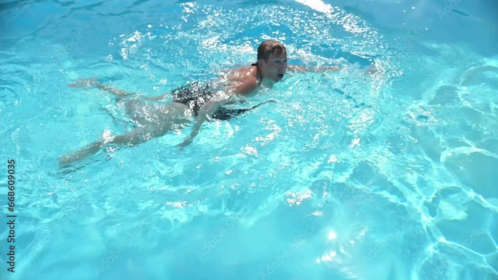 Woman swimming in blue water of pool during weekend Woman swimming in blue water of pool during weekend