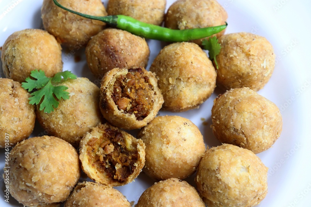Dry Kachori is a deep fried crispy and crunchy balls of maida flour, stuffed with spicy mix of gram flour, sev, Lentils, Tamarind chutney and other Indian spices. A popular tea time snack. Copy Space Dry Kachori is a deep fried crispy and crunchy balls of maida flour, stuffed with spicy mix of gram flour, sev, Lentils, Tamarind chutney and other Indian spices. A popular tea time snack. Copy Space
