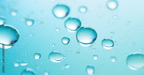 Macro oil drop floating on water surface. Abstract blue water bubbles background. Cosmetic liquid beauty product. Colorful artistic backdrop