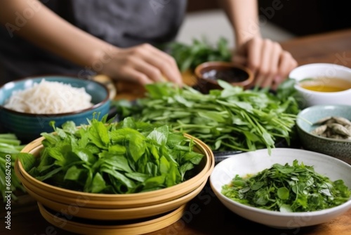 placing a plate of fresh herbs next to a bun cha bowl