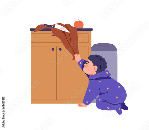 Child in danger at home kitchen. Baby kid playing alone with knife, blade. To...