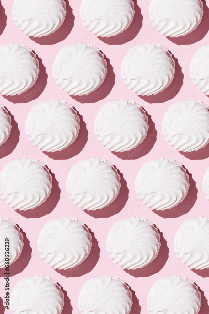 White zephyr on light pink table background in hard light. Pastel color. Closeup White zephyr on light pink table background in hard light. Pastel color. Closeup
