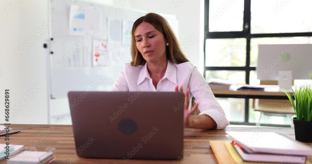Frustrated unhappy woman with laptop in office reading negative news. Businesswoman experiencing stress fatigue and burnout and receiving bad news Frustrated unhappy woman with laptop in office reading negative news. Businesswoman experiencing stress fatigue and burnout and receiving bad news