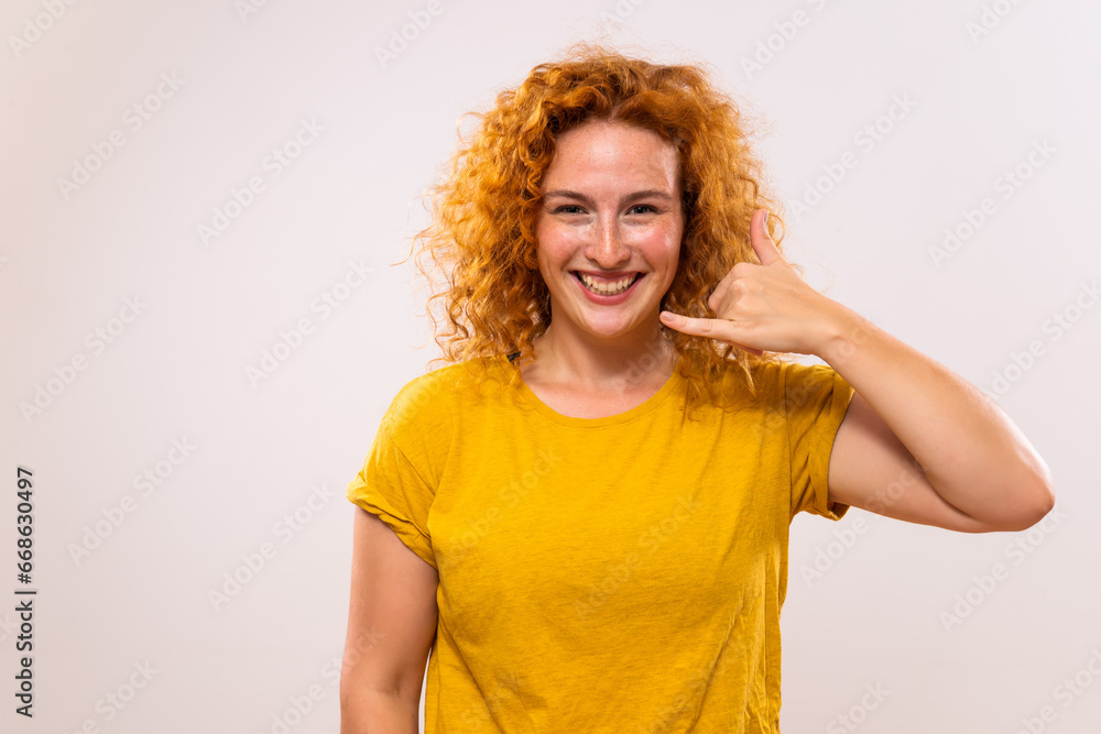 Portrait of happy ginger woman showing call me gesture. Portrait of happy ginger woman showing call me gesture.